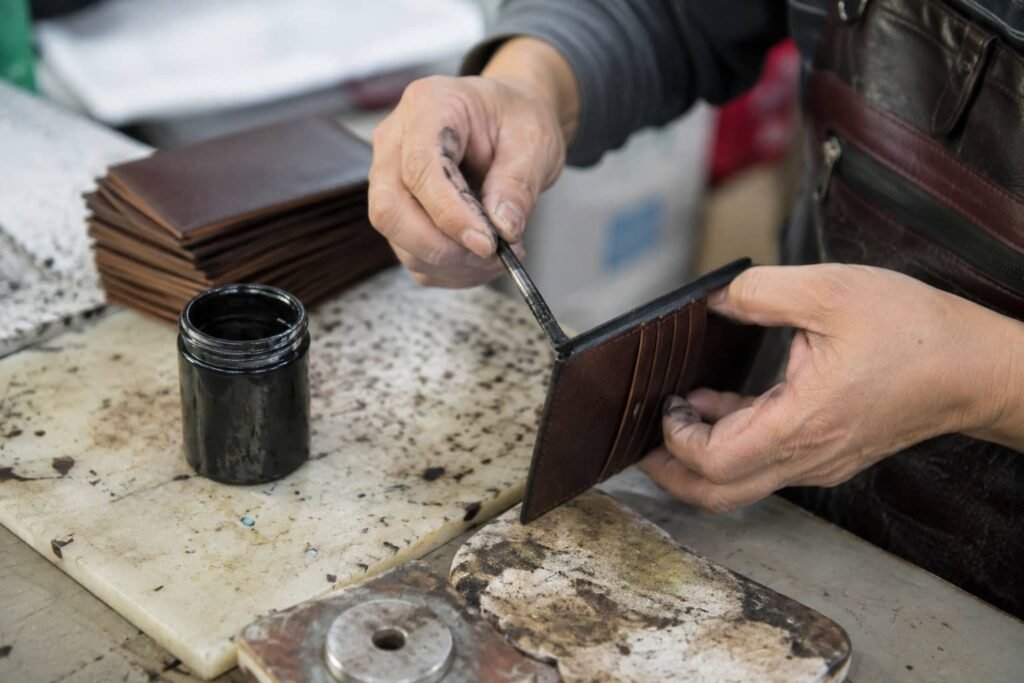 Leather edge painting and burnishing for wallet production